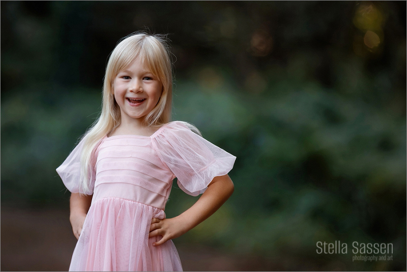Toddler with huge smile, posing for the camera during a family shoot in a foresty area in Cape Town
