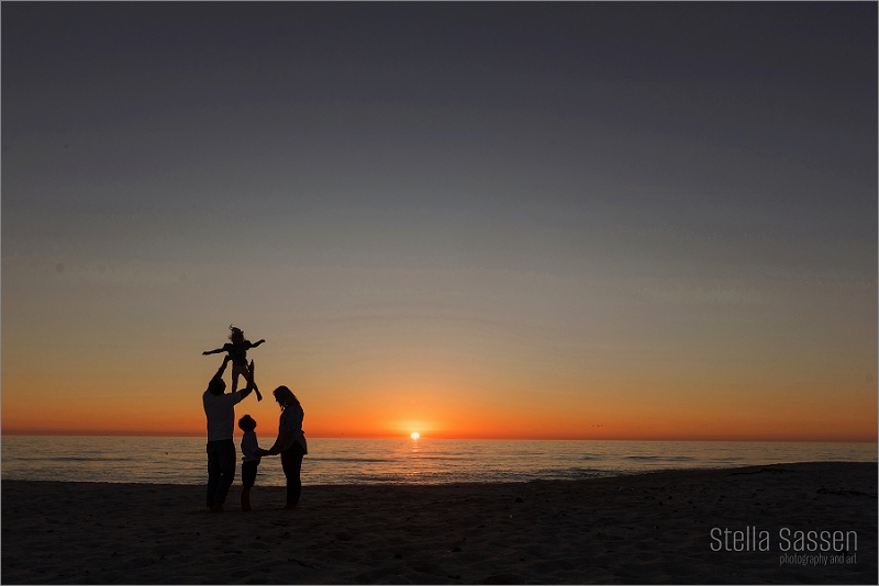 Family silhouette against a beautiful Cape Town sky at the beach