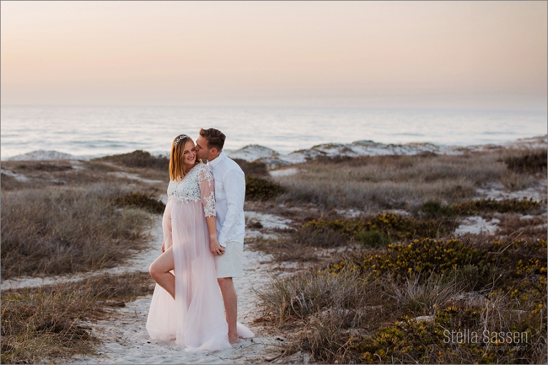 couple maternity photo on beach at sunset