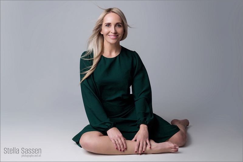 Relaxed headshot for website branding, model sitting on floor in green dress