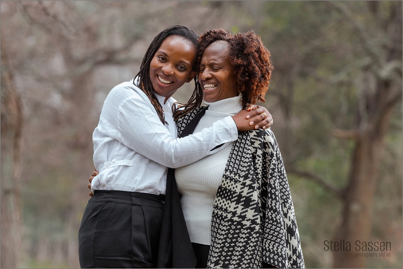 A mother and daughter sharing a fun moment during a family photo shoot in a lush forest near Cape Town