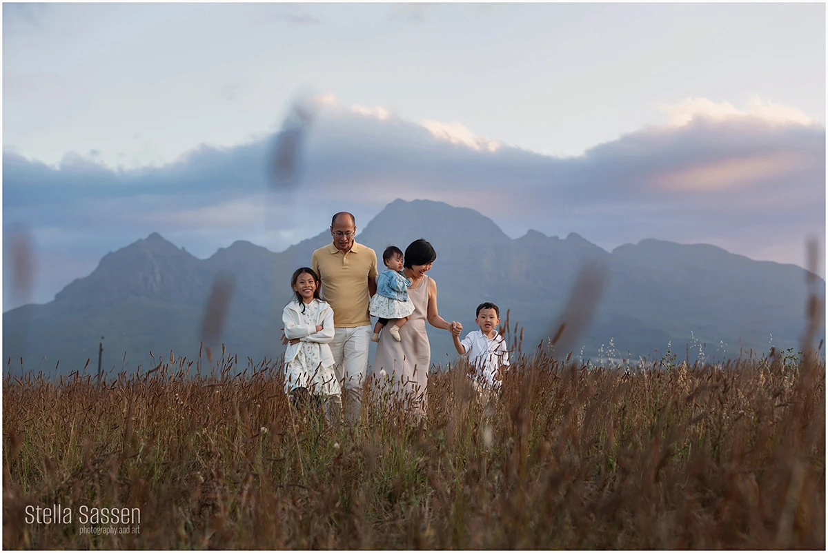 Family photo shoot in field with mountain backdrop in Cape Town