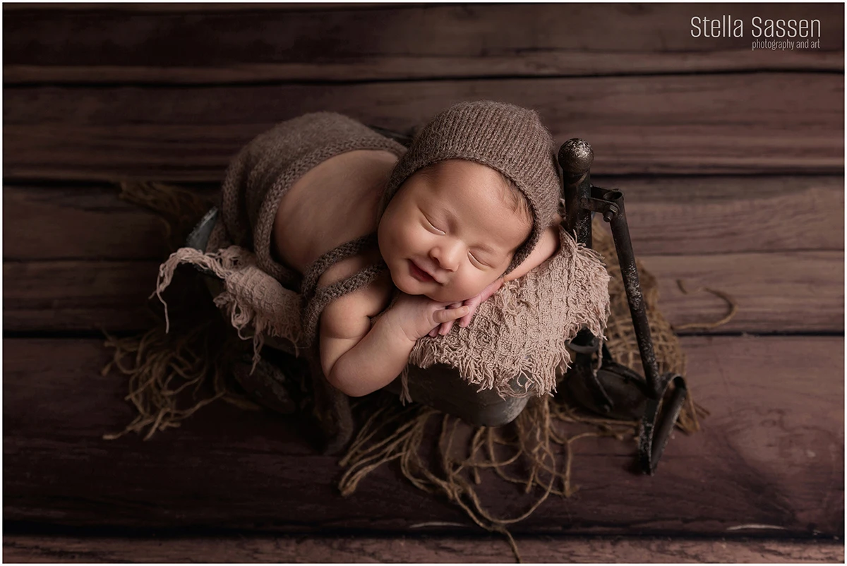 Newborn baby during shoot in prop smiling